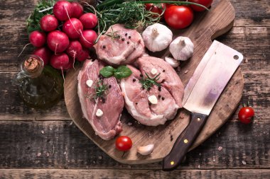 Taze kasap et ürün yelpazesine ahşap masa üzerinde taze biberiye ile süslenmiş kesmek
