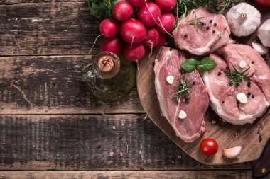 Taze kasap et ürün yelpazesine ahşap masa üzerinde taze biberiye ile süslenmiş kesmek