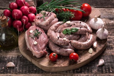 Taze kasap et ürün yelpazesine ahşap masa üzerinde taze biberiye ile süslenmiş kesmek