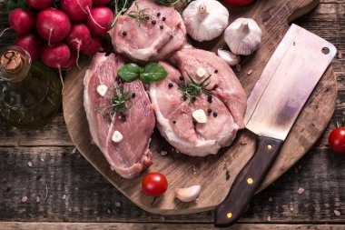 Taze kasap et ürün yelpazesine ahşap masa üzerinde taze biberiye ile süslenmiş kesmek