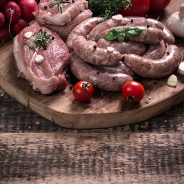 Taze kasap et ürün yelpazesine ahşap masa üzerinde taze biberiye ile süslenmiş kesmek