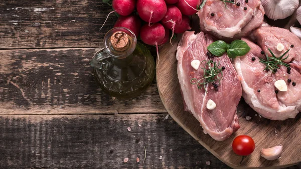 Carnicero fresco corte surtido de carne adornado con romero fresco en mesa de madera — Foto de Stock