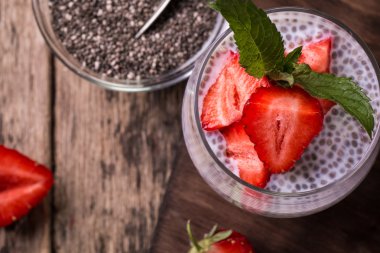 Chia tohum pudingi çilek ve ahşap antika arka plan üzerinde min