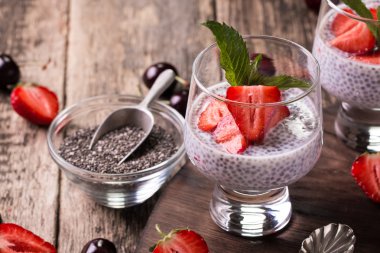 Chia tohum pudingi çilek ve ahşap antika arka plan üzerinde min