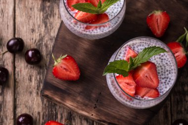 Chia tohum pudingi çilek ve ahşap antika arka plan üzerinde min