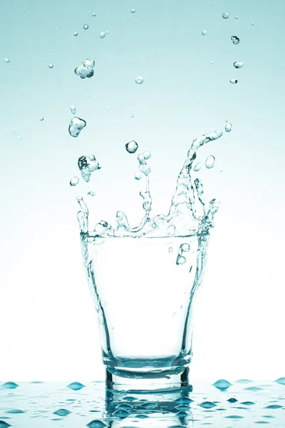 Spruzzi d'acqua in bicchieri isolati su bianco — Foto Stock