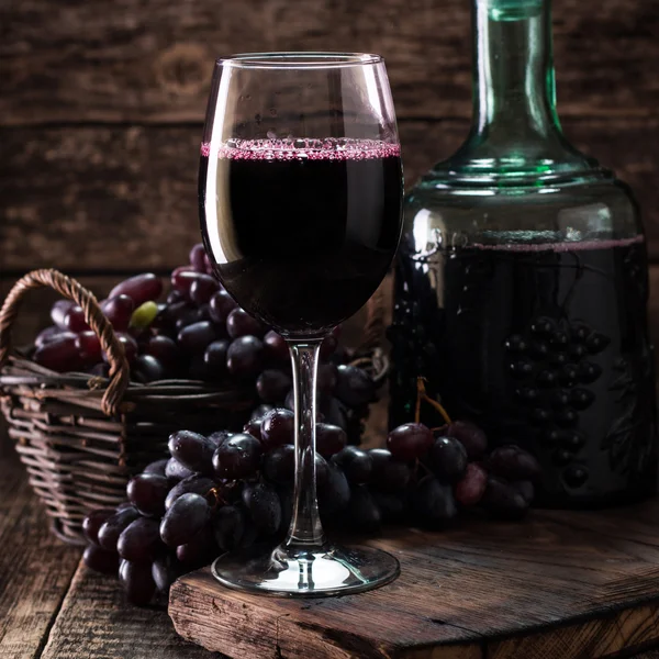 杯红酒，配上一个木制的背景的葡萄 — 图库照片