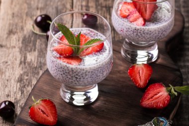 Chia tohum pudingi çilek ve ahşap antika arka plan üzerinde min