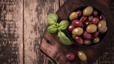 Fesleğen ile ahşap karanlık tabloda zeytin