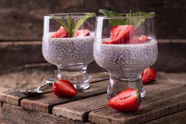 Chia tohum pudingi çilek ve ahşap antika arka plan üzerinde min