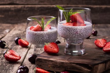 Chia tohum pudingi çilek ve ahşap antika arka plan üzerinde min