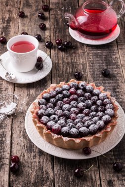 Ahşap antika masa üzerinde kiraz ve çırpılmış kremalı tart