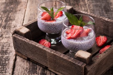 Chia tohum pudingi çilek ve ahşap antika arka plan üzerinde min