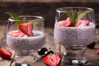 Chia tohum pudingi çilek ve ahşap antika arka plan üzerinde min