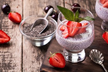 Chia tohum pudingi çilek ve ahşap antika arka plan üzerinde min