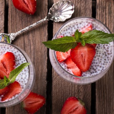 Chia tohum pudingi çilek ve ahşap antika arka plan üzerinde min