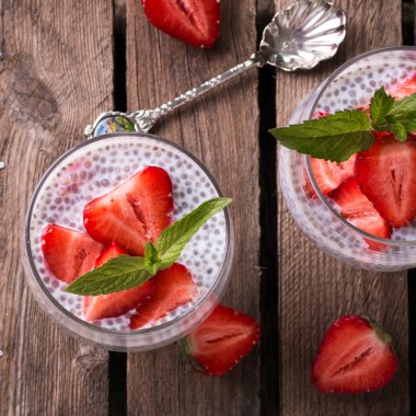 Chia tohum pudingi çilek ve ahşap antika arka plan üzerinde min