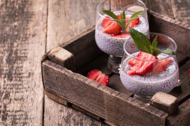 Chia tohum pudingi çilek ve ahşap antika arka plan üzerinde min