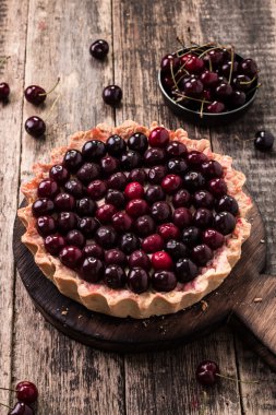 Ahşap antika masa üzerinde kiraz ve çırpılmış kremalı tart