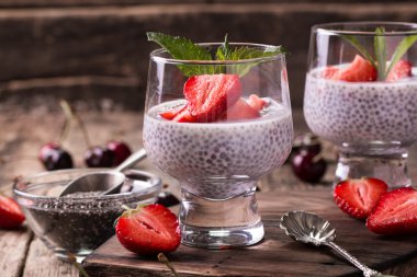 Chia tohum pudingi çilek ve ahşap antika arka plan üzerinde min