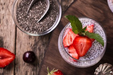 Chia tohum pudingi çilek ve ahşap antika arka plan üzerinde min