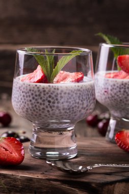 Chia tohum pudingi çilek ve ahşap antika arka plan üzerinde min