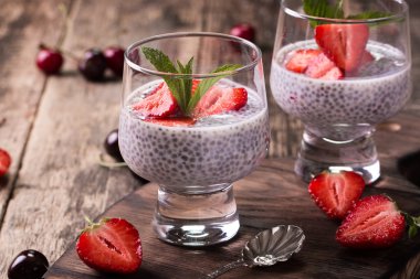 Chia tohum pudingi çilek ve ahşap antika arka plan üzerinde min