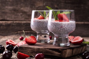 Chia tohum pudingi çilek ve ahşap antika arka plan üzerinde min