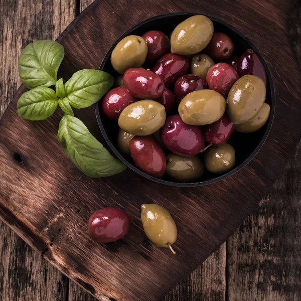 Fesleğen ile ahşap karanlık tabloda zeytin