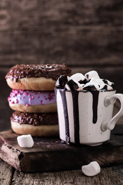 Rosquillas y una taza de café con chocolate en una mesa de madera — Foto de Stock