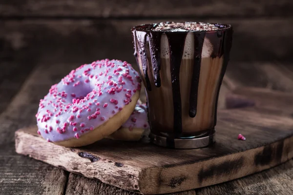 Rosquillas y una taza de café con chocolate en una mesa de madera — Foto de Stock