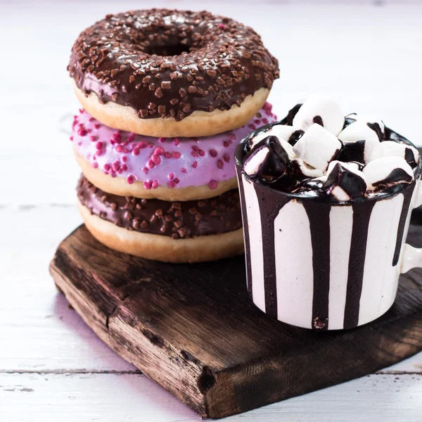 Rosquillas y una taza de café con chocolate en una mesa de madera — Foto de Stock