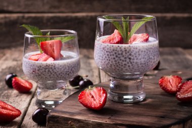 Chia tohum pudingi çilek ve ahşap antika arka plan üzerinde min