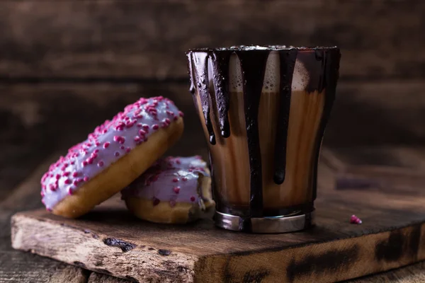 Rosquillas y una taza de café con chocolate en una mesa de madera — Foto de Stock