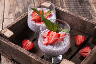 Chia tohum pudingi çilek ve ahşap antika arka plan üzerinde min