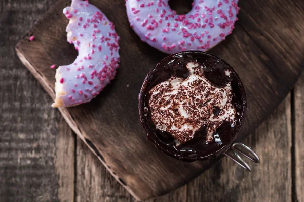 Rosquillas y una taza de café con chocolate en una mesa de madera — Foto de Stock