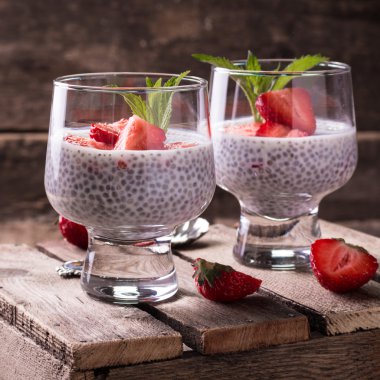 Chia tohum pudingi çilek ve ahşap antika arka plan üzerinde min