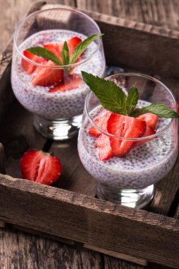 Chia tohum pudingi çilek ve ahşap antika arka plan üzerinde min