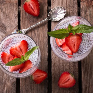 Chia tohum pudingi çilek ve ahşap antika arka plan üzerinde min