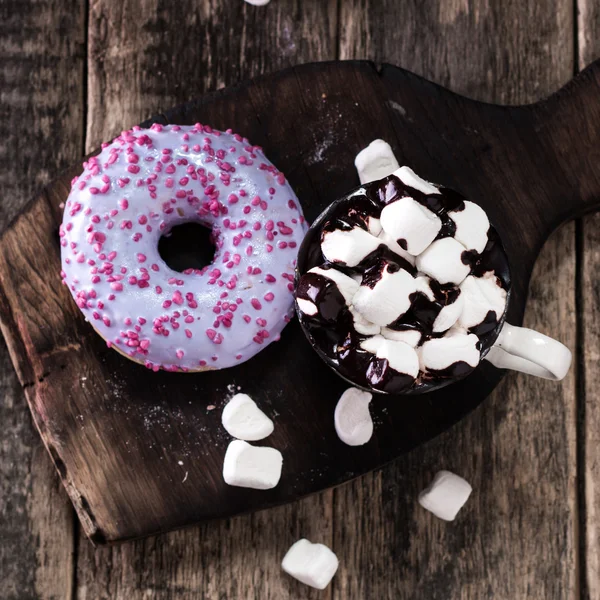 Rosquillas y una taza de café con chocolate en una mesa de madera — Foto de Stock