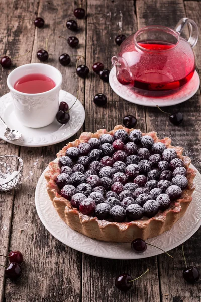 Tart with cherry and whipped cream on wooden vintage table