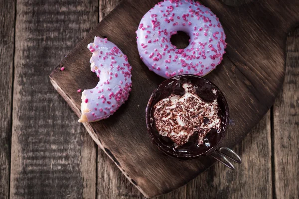 Rosquillas y una taza de café con chocolate en una mesa de madera — Foto de Stock