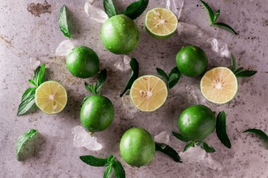 Arka plan kireç. Taze limon dilimleri ve nane yaprakları etrafında.