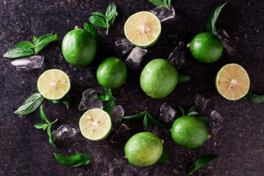 Arka plan kireç. Taze limon dilimleri ve nane yaprakları etrafında.