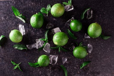 Arka plan kireç. Taze limon dilimleri ve nane yaprakları etrafında.