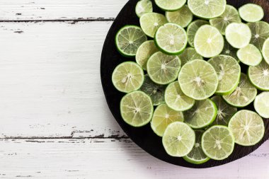 Arka plan kireç. Taze limon dilimleri ve nane yaprakları etrafında.