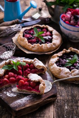 Yaban mersini, kiraz, ahududu ve blackcurrant Galette'ye w ahşap zemin üzerine.