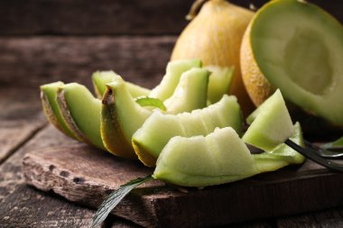 Dilimlenmiş taze kavun ve ahşap masa, sağlıklı gıda nane