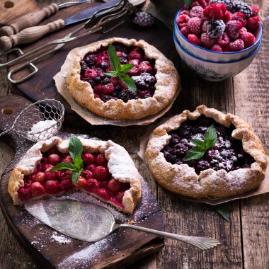 Yaban mersini, kiraz, ahududu ve blackcurrant Galette'ye w ahşap zemin üzerine.