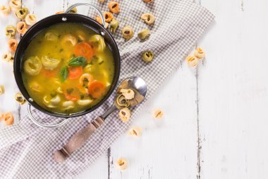 Beyaz ahşap masa üzerinde Tortellini lezzetli sebze çorbası